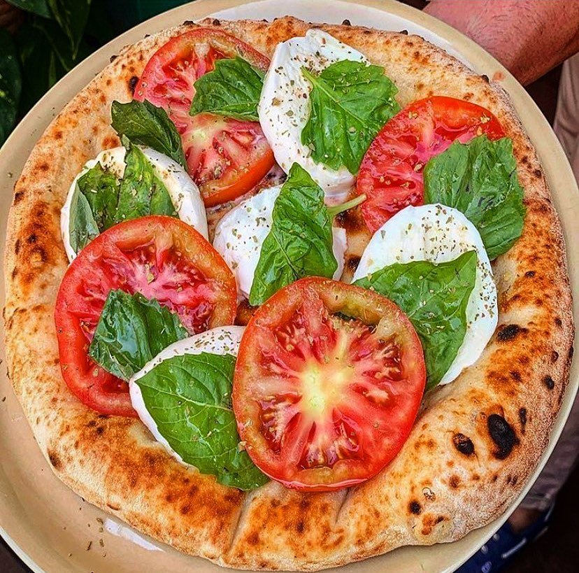 11 Trendy Neapolitan Pizza Flavors To Try At Home 5 A delicious Caprese pizza topped with mozzarella, cherry tomatoes, and basil, drizzled with balsamic glaze.