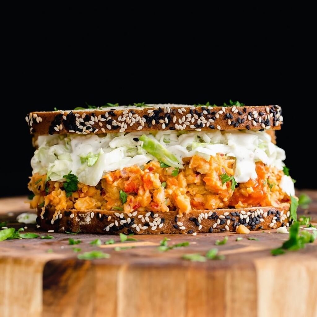 A delicious chickpea salad sandwich with lettuce and tomato on whole grain bread.