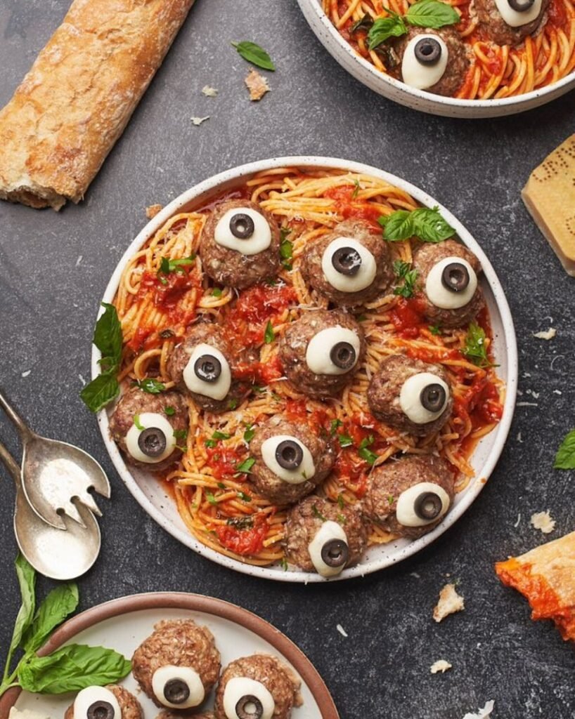 9 Best Halloween Party Treats Sure To Spook Your Guests 7 A plate of Bloody Eyeball Meatballs in marinara sauce, topped with cheese balls and black olives