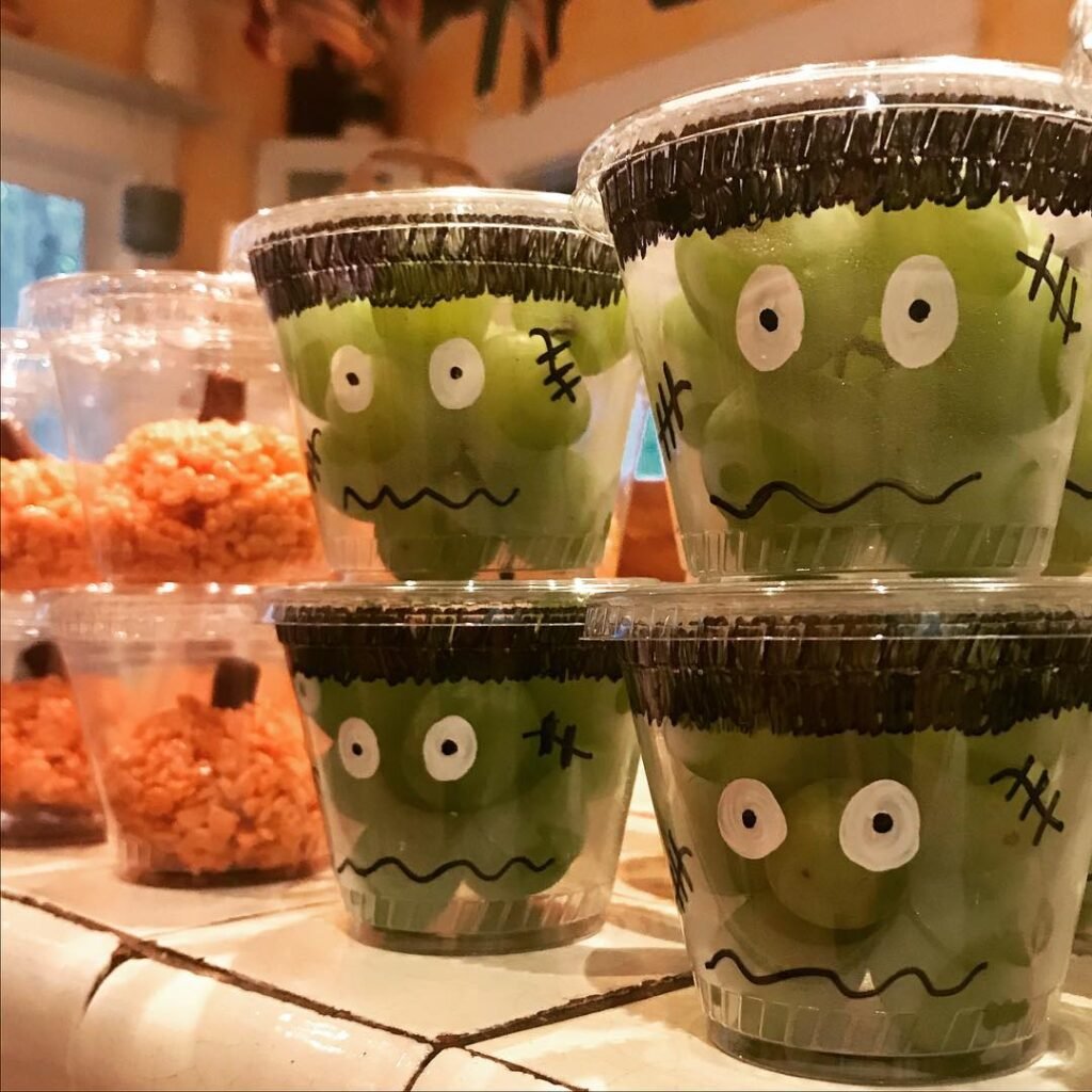 9 Best Halloween Party Treats Sure To Spook Your Guests 5 Colorful Frankenstein Fruit Cups with fruit layers, whipped cream, and candy eyes