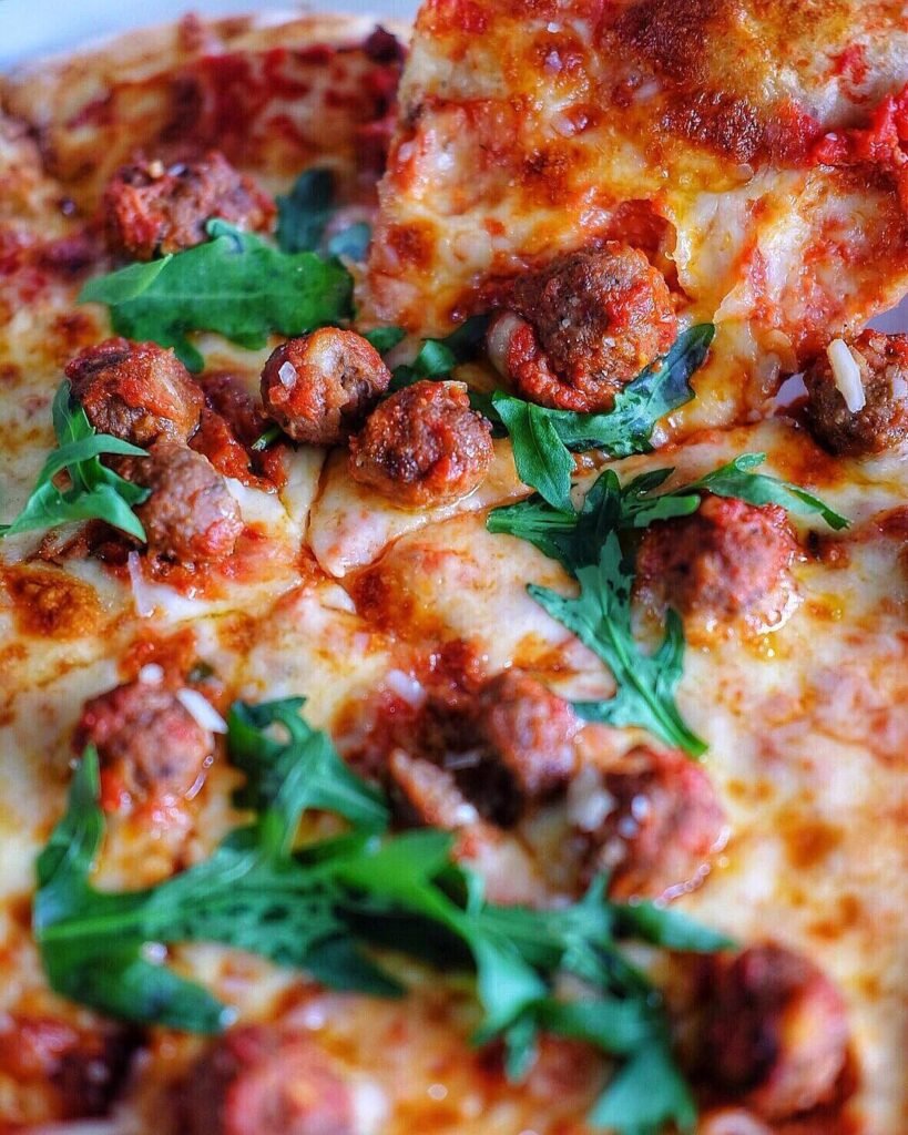 13 Easy And Delicious Grandma Pizza Recipes You Need To Try 14 A delicious Spicy Italian Meatball Pizza topped with fresh basil and served on a wooden table.