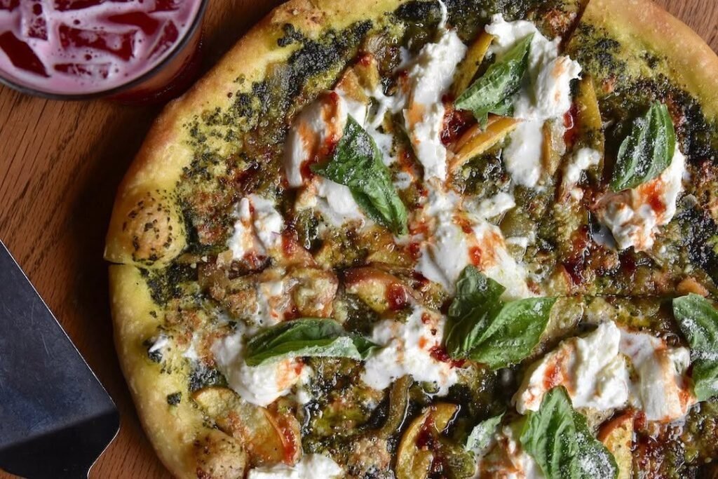 11 Trendy Neapolitan Pizza Flavors To Try At Home 10 A delicious peach and burrata pizza topped with fresh basil, served outdoors.