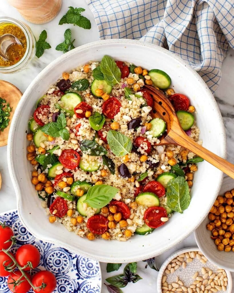 A vibrant quinoa salad with roasted vegetables including zucchini, bell peppers, and cherry tomatoes.