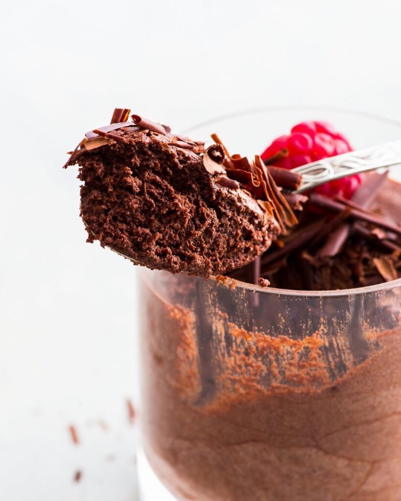 Vegan chocolate mousse served in elegant glasses, topped with strawberries and blueberries.