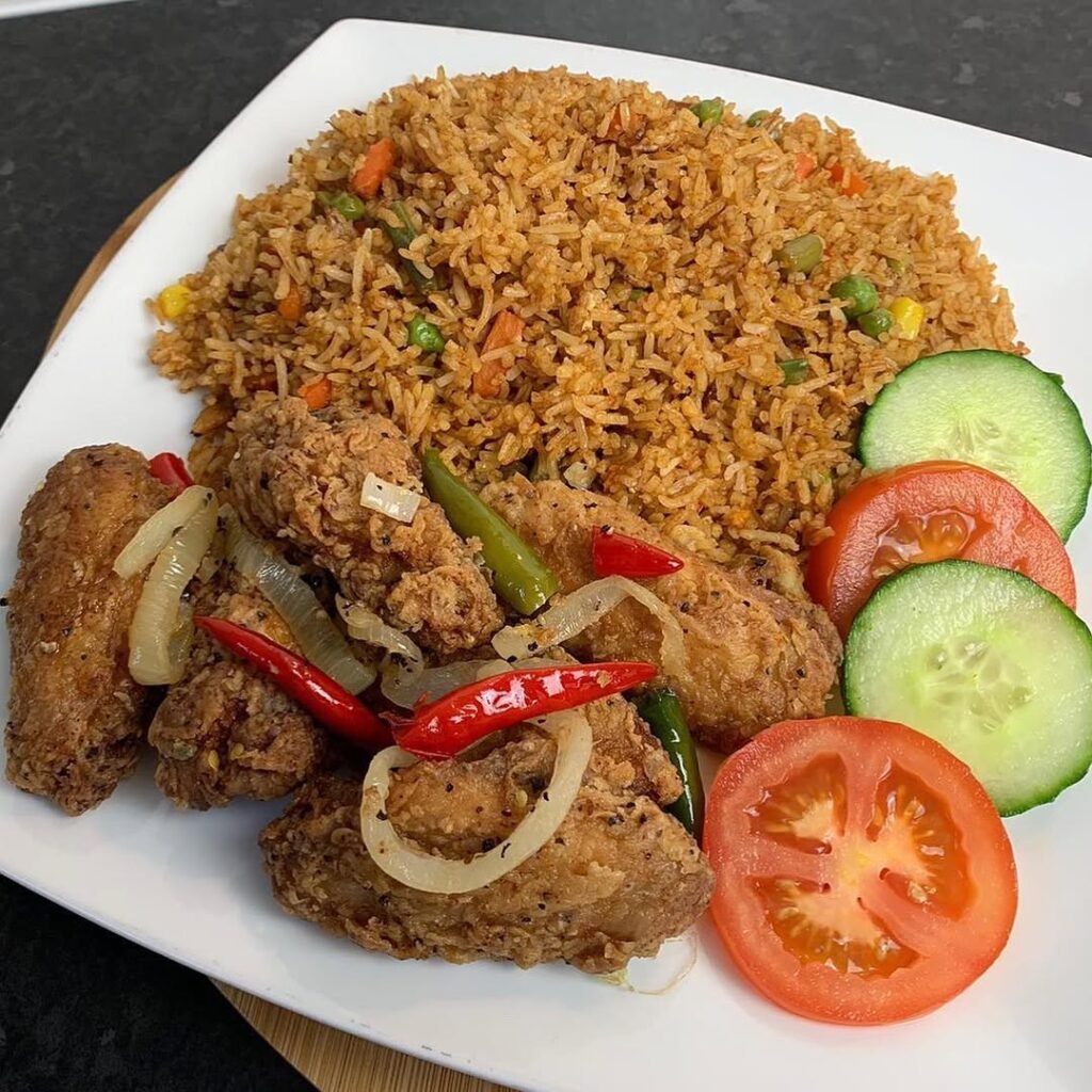 A plate of vegetable fried rice topped with a fried egg and garnished with green peas and bell peppers.