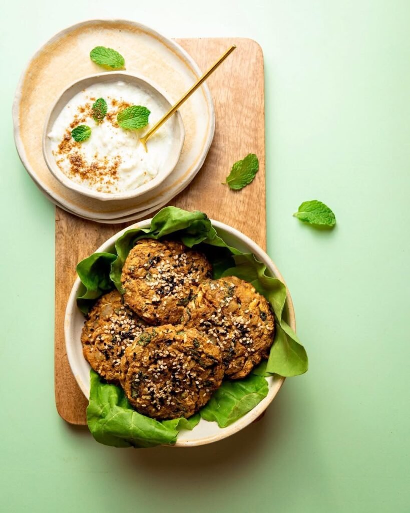Zucchini and Spinach Patties on a plate with fresh ingredients around