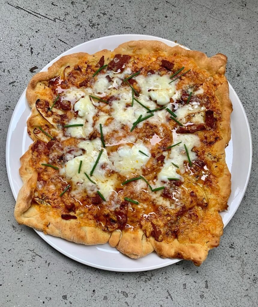 A delicious apple and cheddar pizza with slices of apple on top.