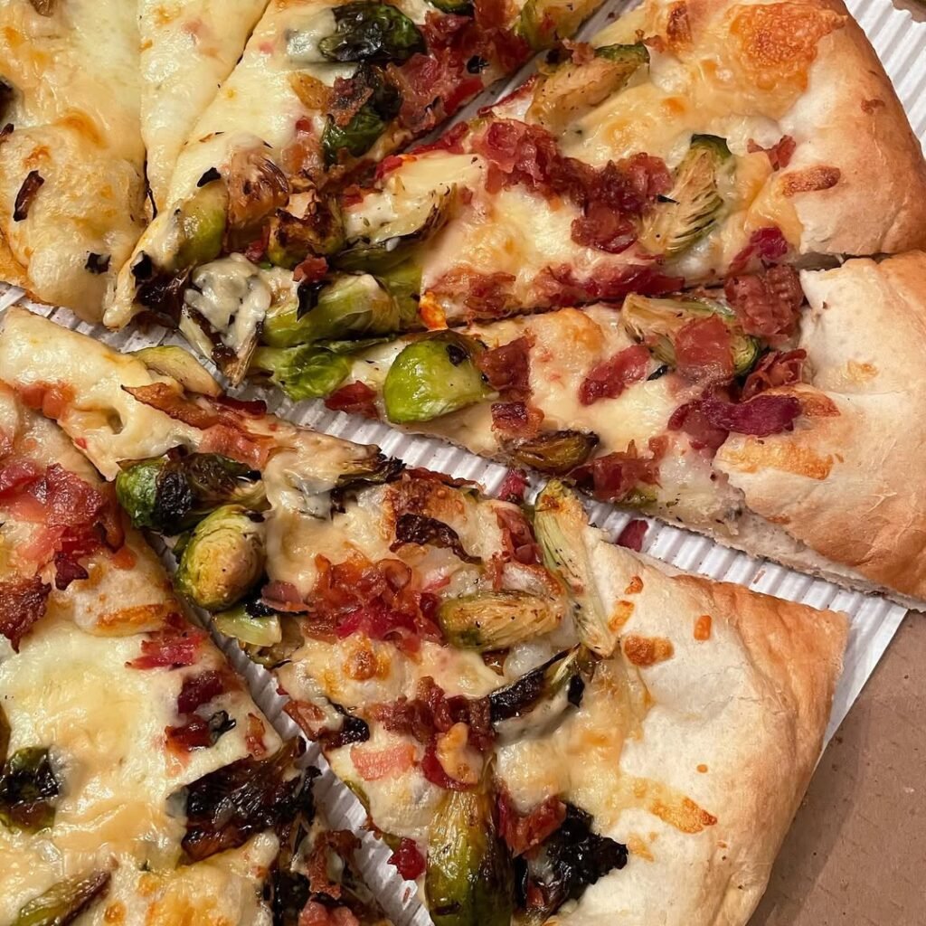 Maple Bacon and Brussels Sprouts pizza on a wooden surface