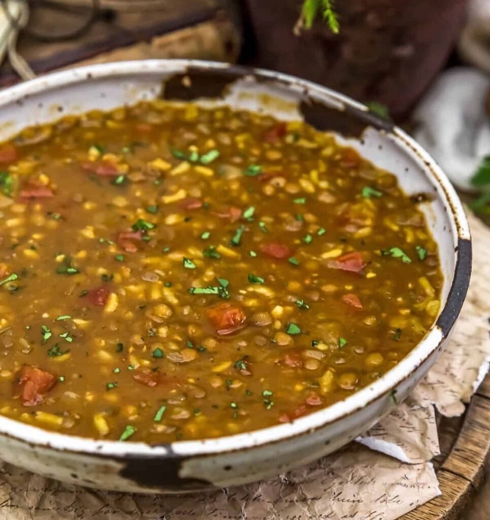 A bowl of brown rice and lentil stew with colorful vegetables.
