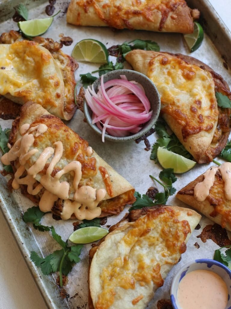 Crispy chicken and mushroom tacos on a colorful plate with lime and cilantro