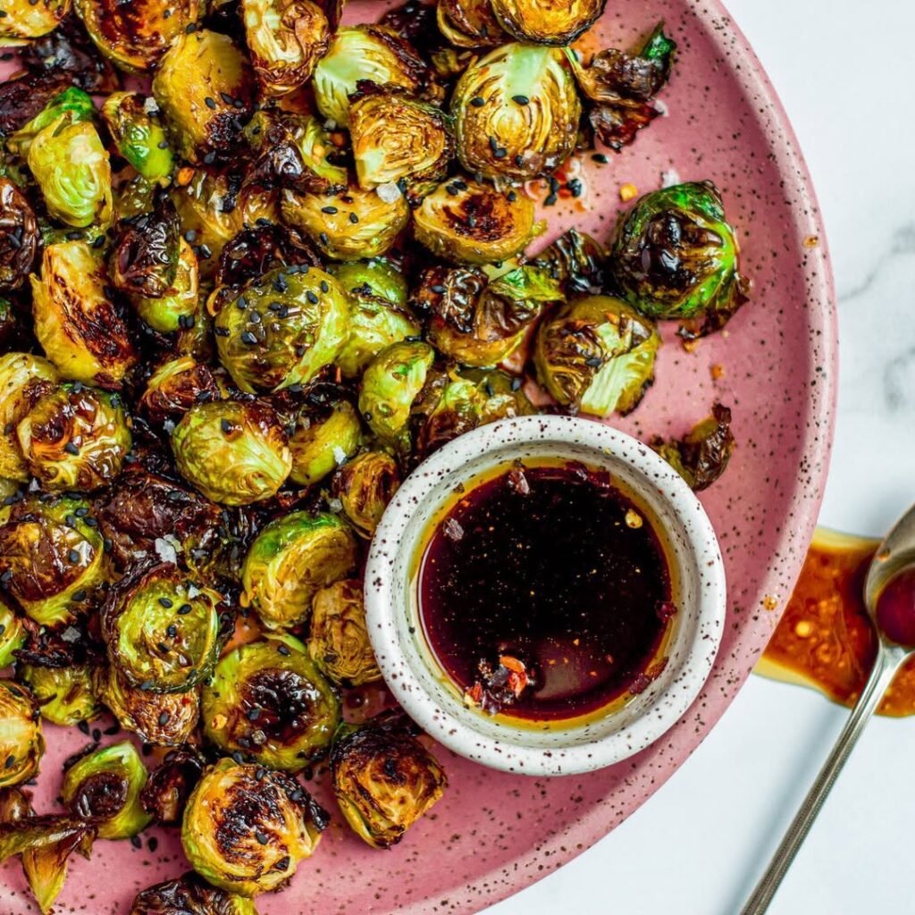 5 Fall Grilling Recipes To Warm Up The Chilly Season 3 Maple glazed grilled Brussels sprouts in a bowl, surrounded by autumn vegetables.