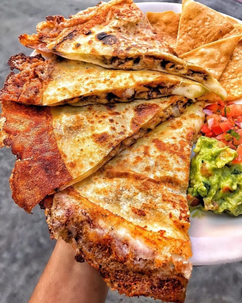 Delicious mushroom and chicken quesadillas served with sour cream and salsa.
