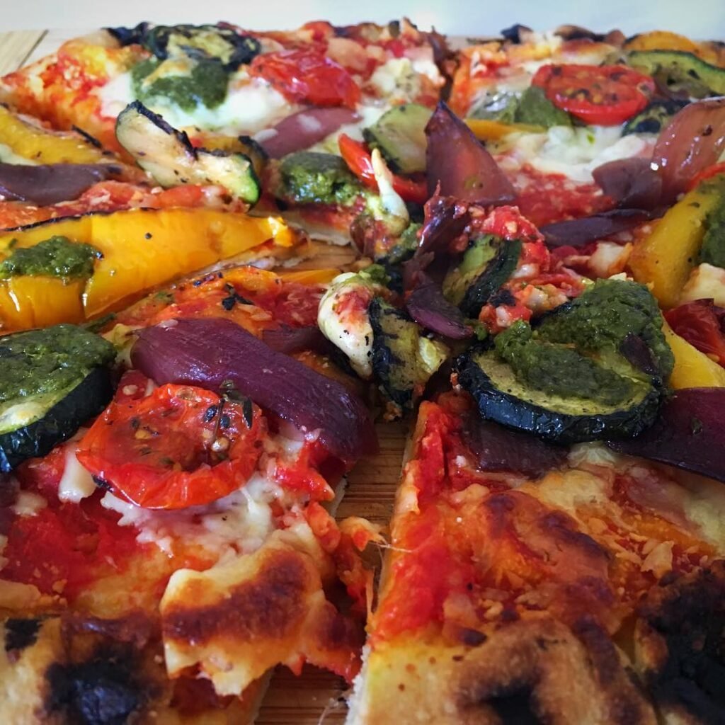 A delicious pizza topped with roasted vegetables and fresh basil