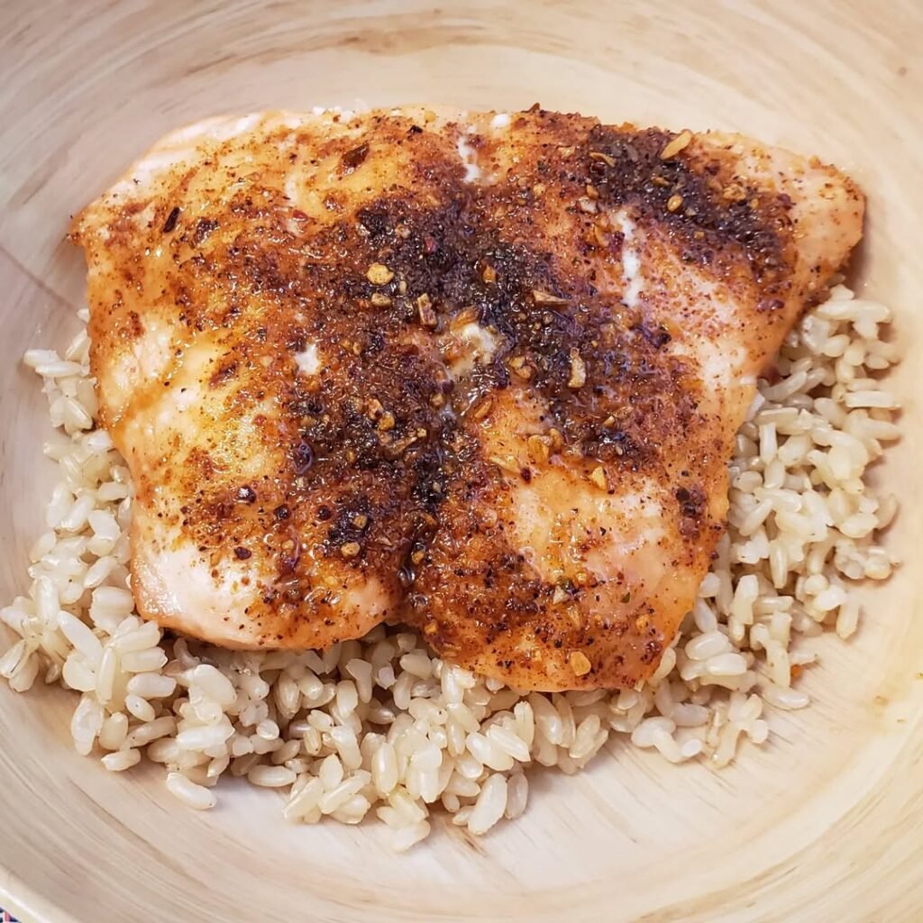 6 Homemade Dog Food Recipes To Soothe Itchy Skin 5 A plate of salmon served over brown rice with herbs, showcasing a nutritious meal for dogs.