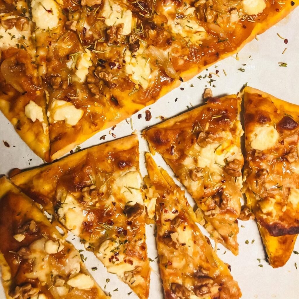 A delicious pizza topped with sweet potatoes, kale, and feta cheese.