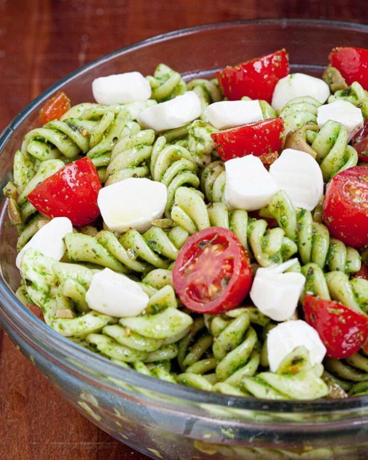A bowl of Caprese Pasta Salad with cherry tomatoes, mozzarella, and basil.