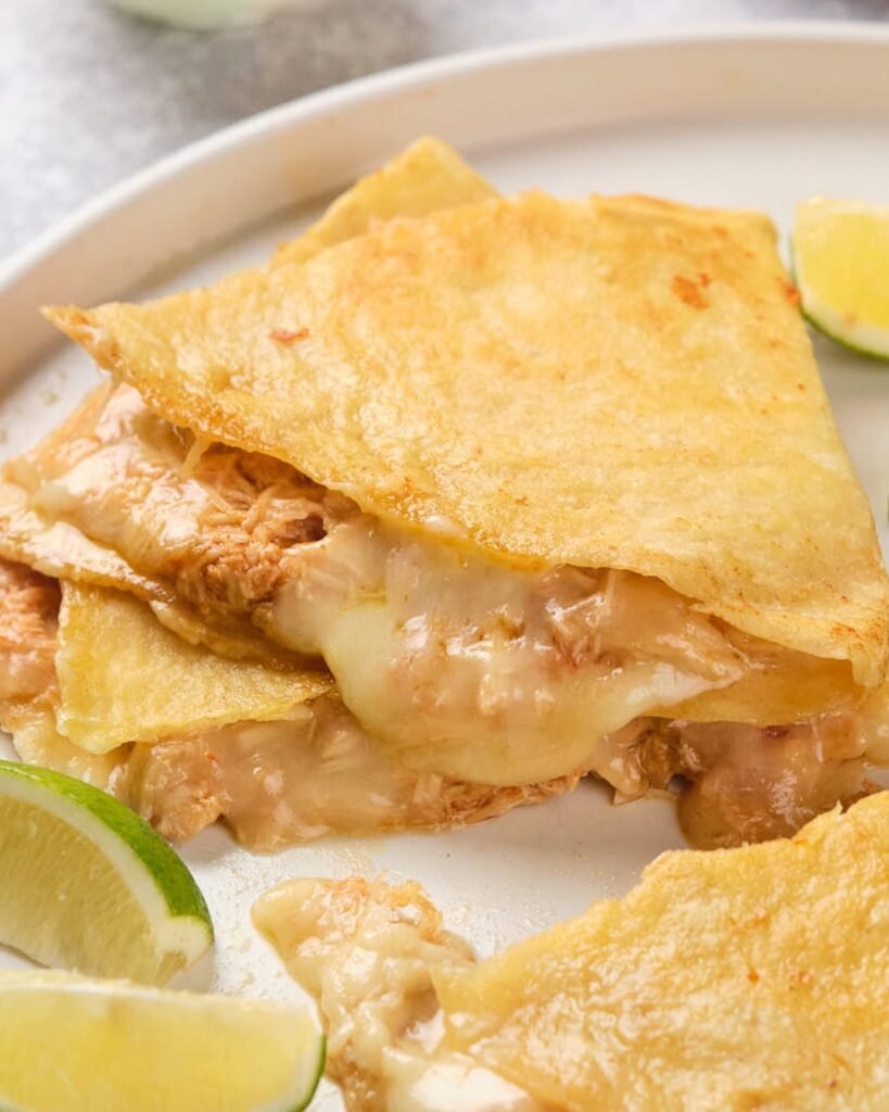 Cheesy chicken quesadillas on a colorful plate with dipping sauce