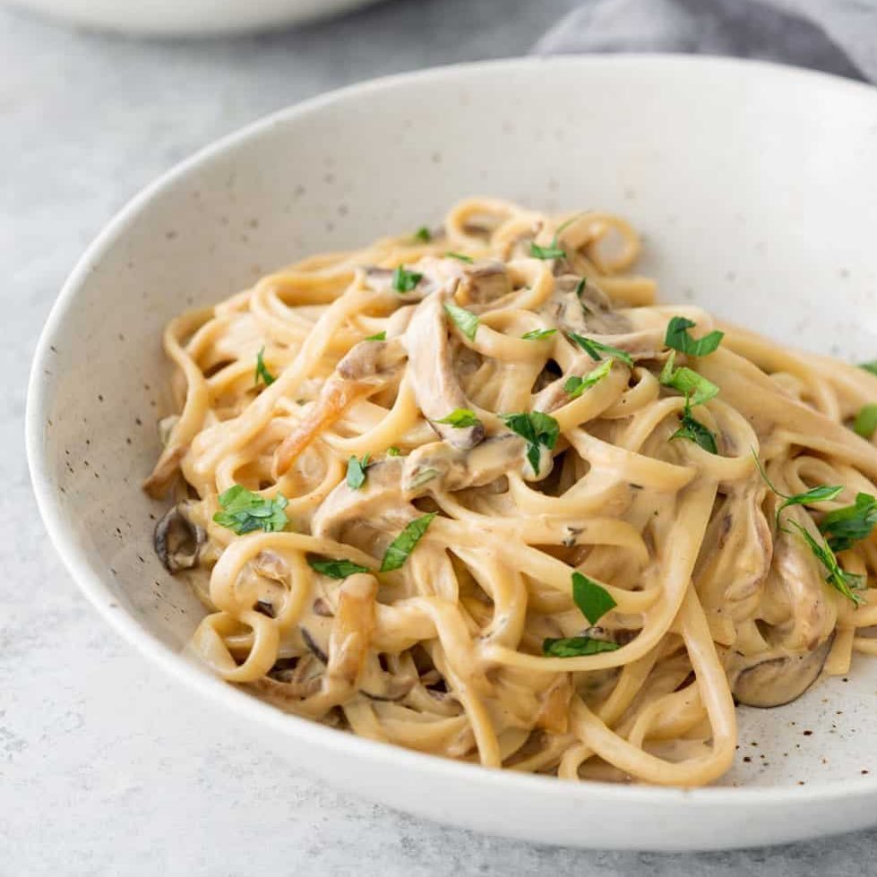 10 Delicious Vegetarian Pasta Recipes to Savor 7 A bowl of fettuccine pasta topped with mushrooms and garnished with parsley.