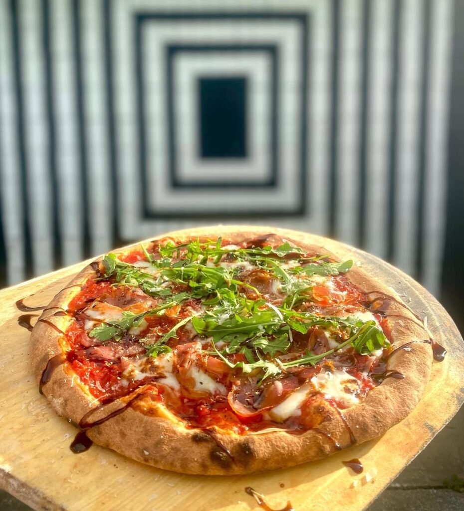 Pizza topped with prosciutto and arugula