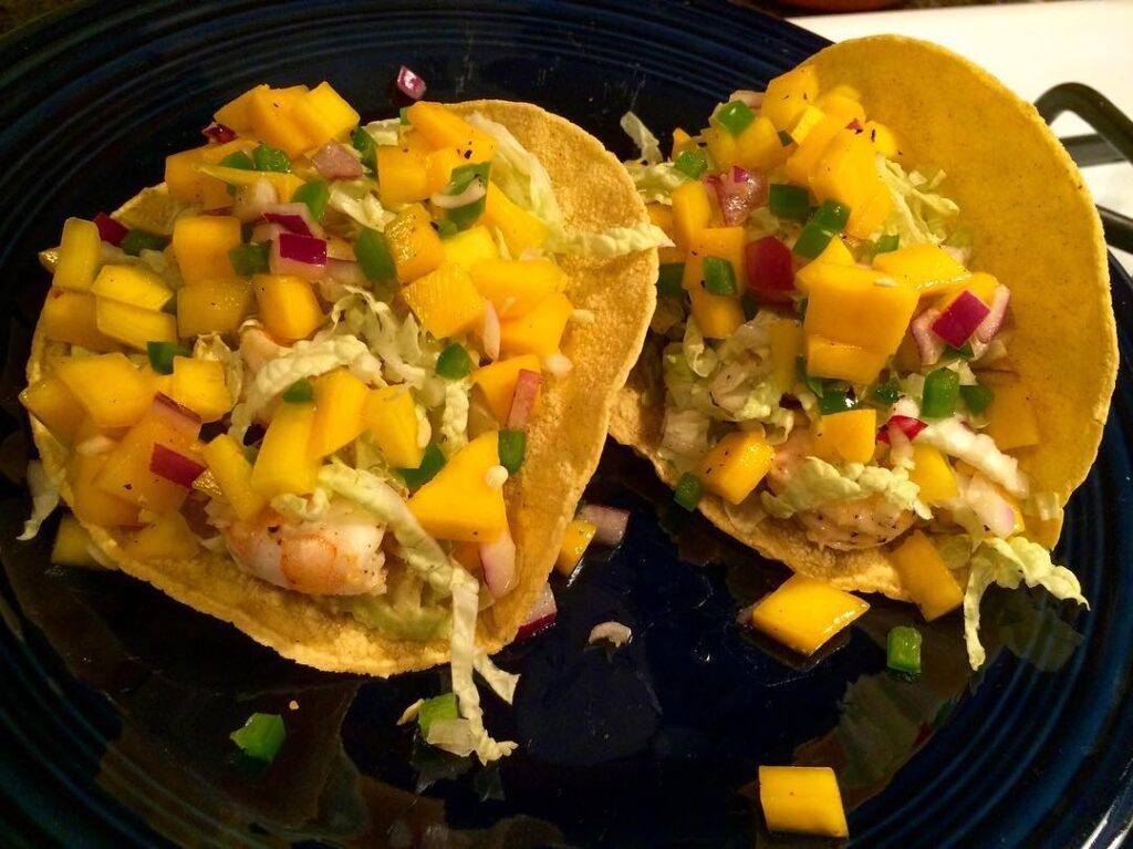 12 Delicious Birthday Dinner Recipes You’ll Love 13 Zesty shrimp tacos with mango salsa on a colorful plate