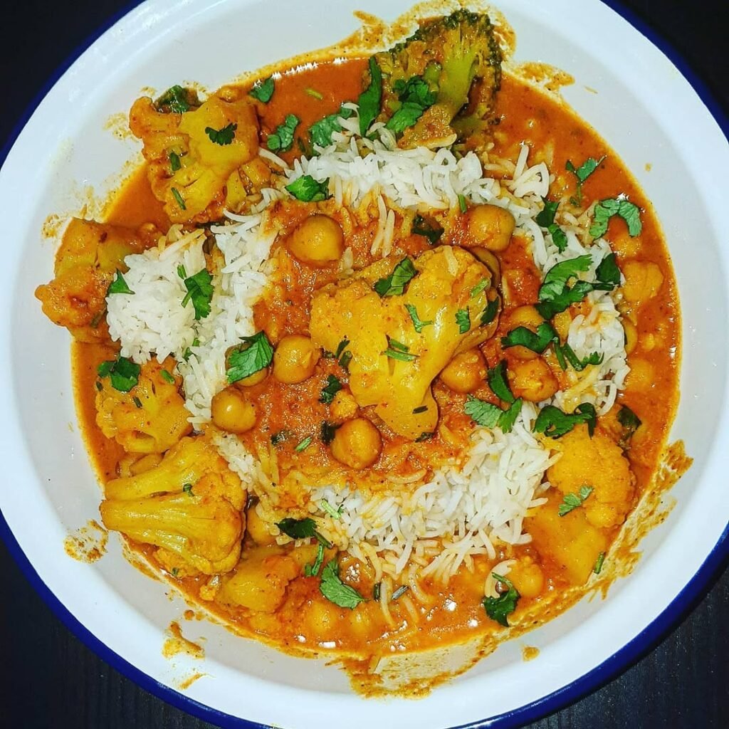 8 Meatless Monday Recipes To Try Tonight 4 A bowl of cauliflower and chickpea curry served with rice and garnished with cilantro.