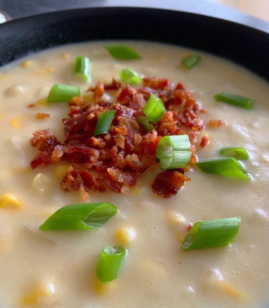 12 Creamy Potato Soup Recipes to Warm Your Soul 11 A bowl of creamy potato and corn chowder topped with fresh herbs.