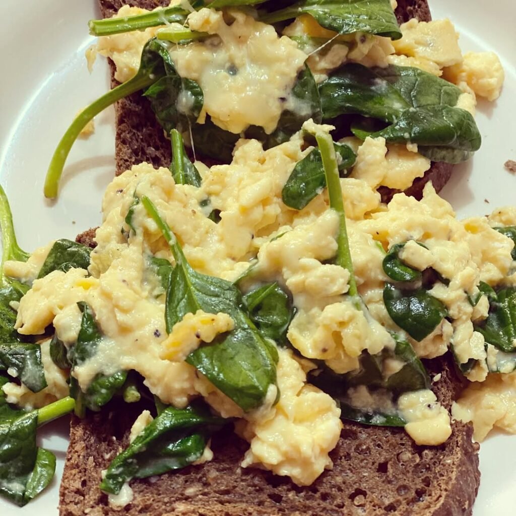 A plate of egg and spinach scramble with dog treats