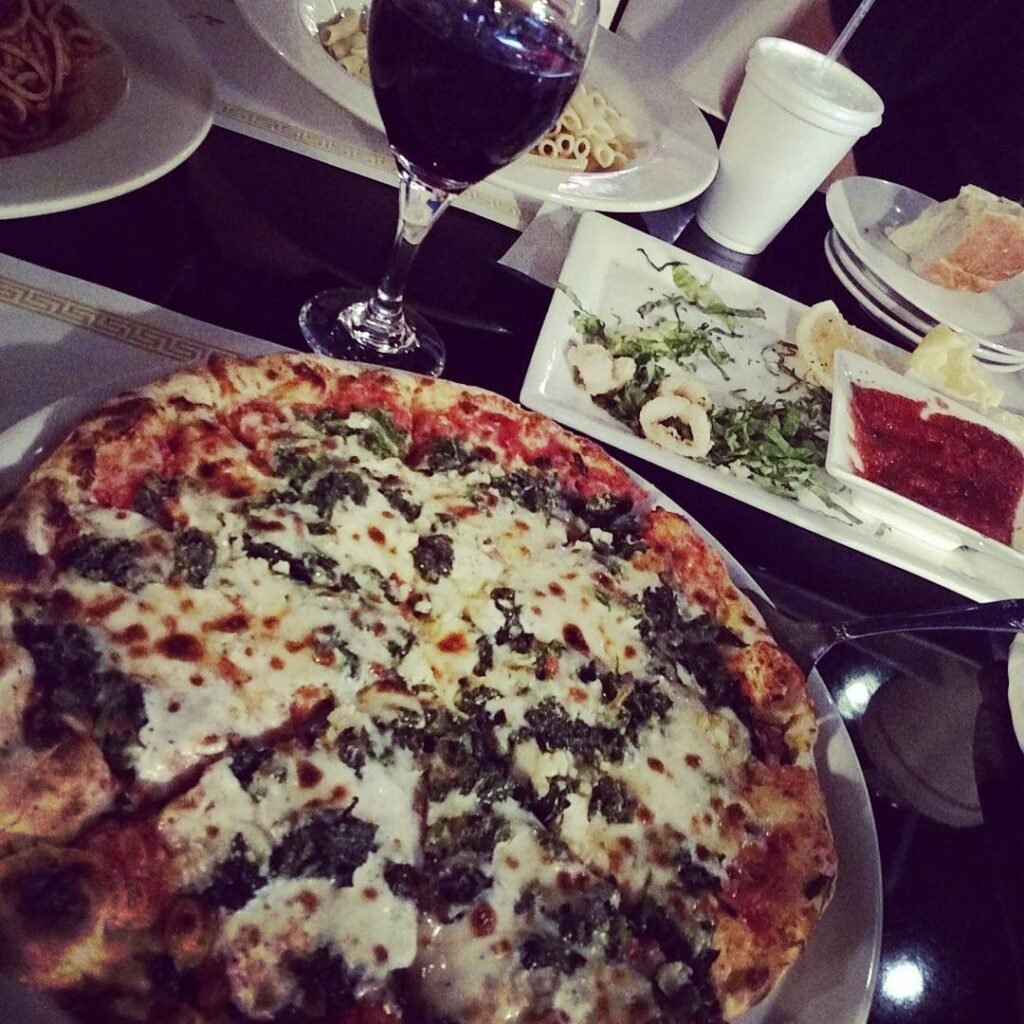 A delicious pizza topped with mozzarella and fresh spinach on a baking sheet.