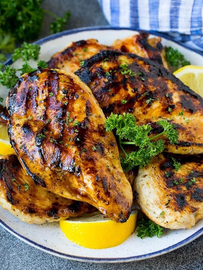 Grilled chicken with lemon slices and colorful vegetables