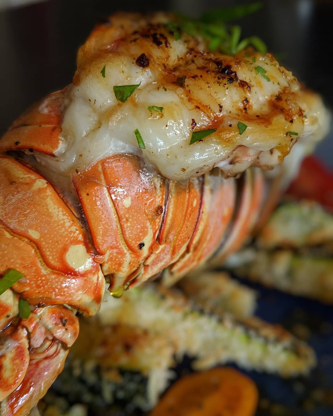 12 Delicious Birthday Dinner Recipes You’ll Love 4 A beautifully presented lobster tail with garlic butter and lemon wedges on a plate.