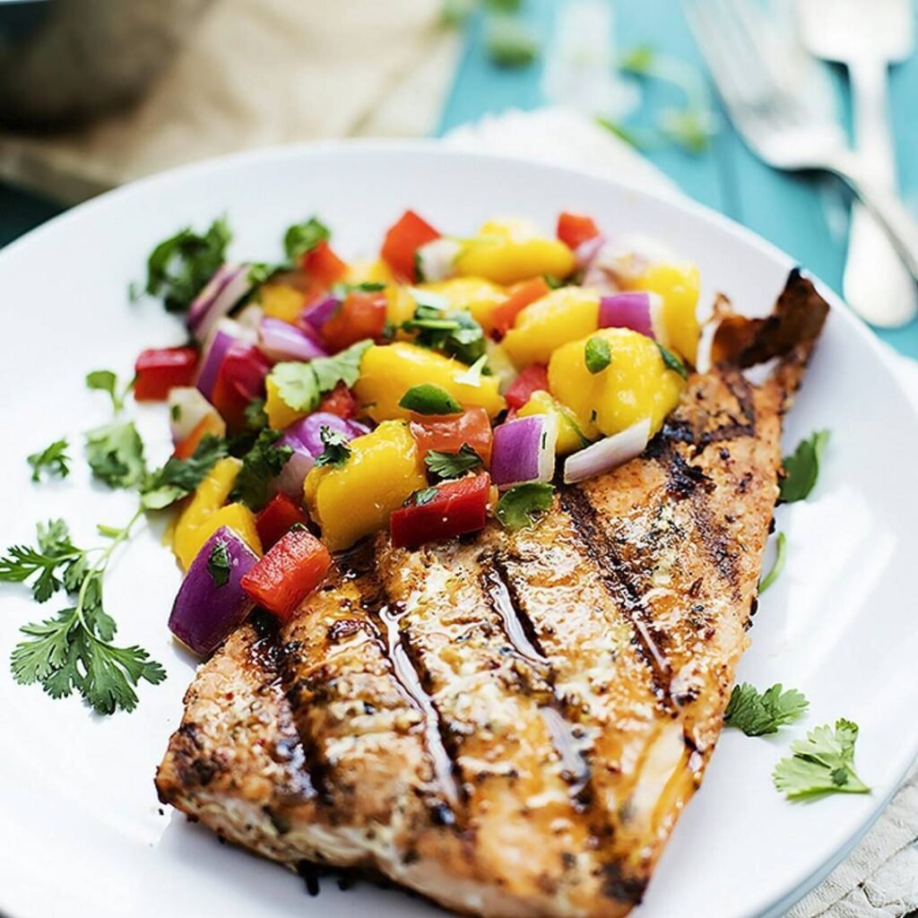 Grilled fish topped with mango salsa and served with asparagus.
