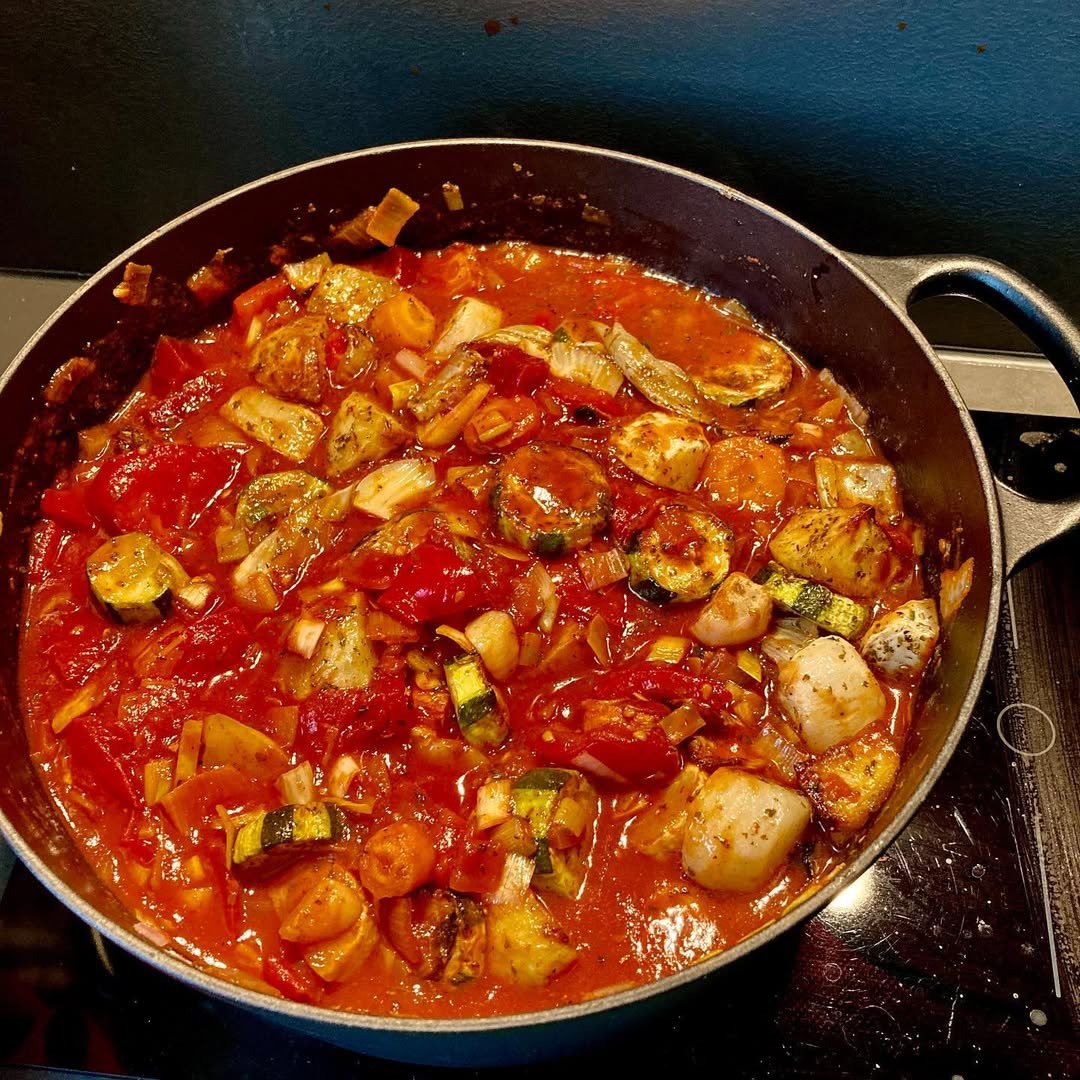 13 Delicious Recipes to Make with Tomato Soup 10 A bowl of Mediterranean tomato soup with olives and feta cheese, garnished with parsley.