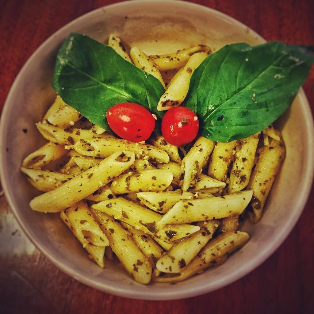 10 Delicious Vegetarian Pasta Recipes to Savor 3 A bowl of Pesto Penne with Cherry Tomatoes, featuring vibrant colors and fresh ingredients.