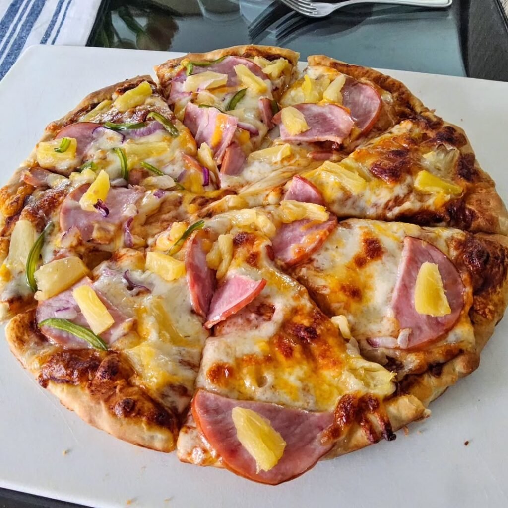 Pizza topped with pineapple and Canadian bacon