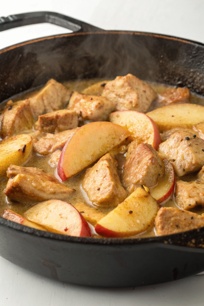 A delicious mix of pork pieces and sliced apples in a skillet.