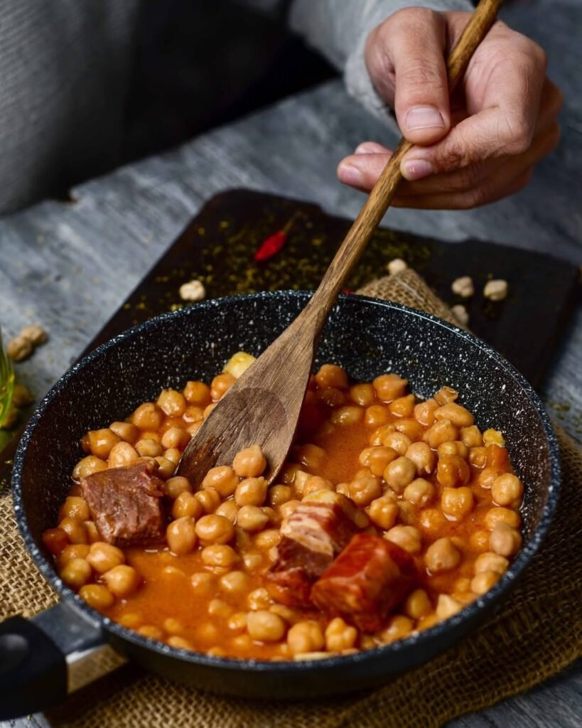 A bowl of Spanish Cocido Madrileño with chickpeas and vegetables.