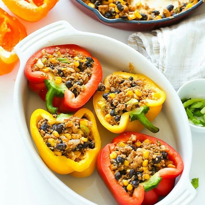 8 Meatless Monday Recipes To Try Tonight 5 Colorful stuffed bell peppers filled with black beans and rice on a plate.
