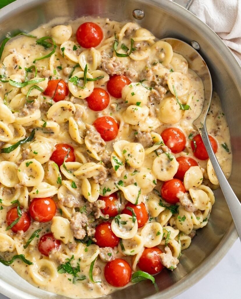 13 Delicious Recipes to Make with Tomato Soup 7 A bowl of creamy tomato basil pasta topped with fresh basil and cherry tomatoes.