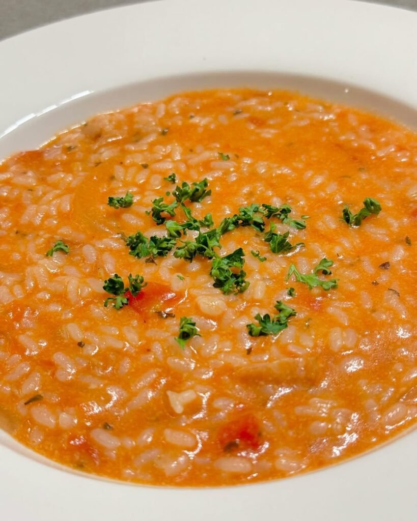 13 Delicious Recipes to Make with Tomato Soup 9 A bowl of creamy tomato soup risotto topped with Parmesan and fresh herbs.