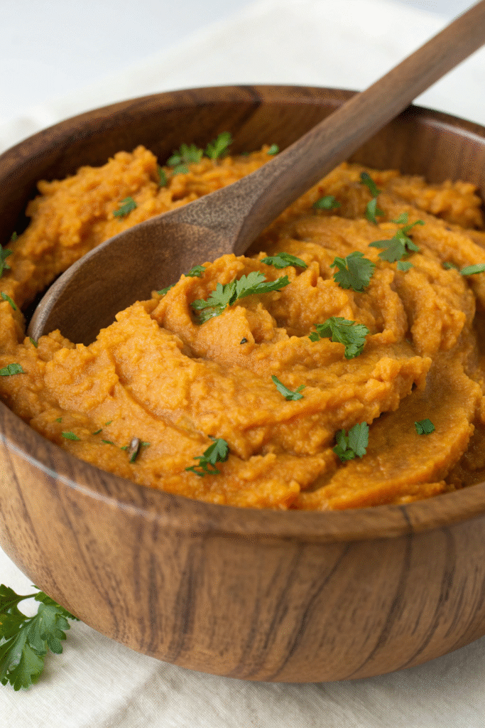 A colorful bowl of vegetable and lentil mash, garnished with parsley and cherry tomatoes.