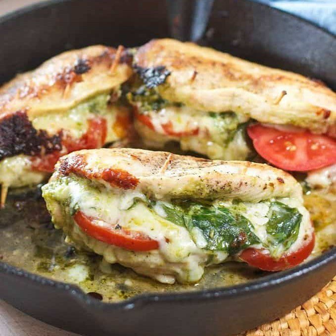 Caprese stuffed chicken breasts with mozzarella, tomatoes, and basil on a plate